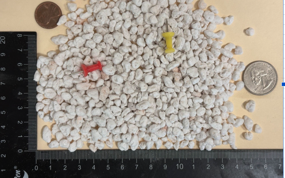 Super Coarse Plus grade expanded perlite particles shown next to a ruler and coin for scale reference